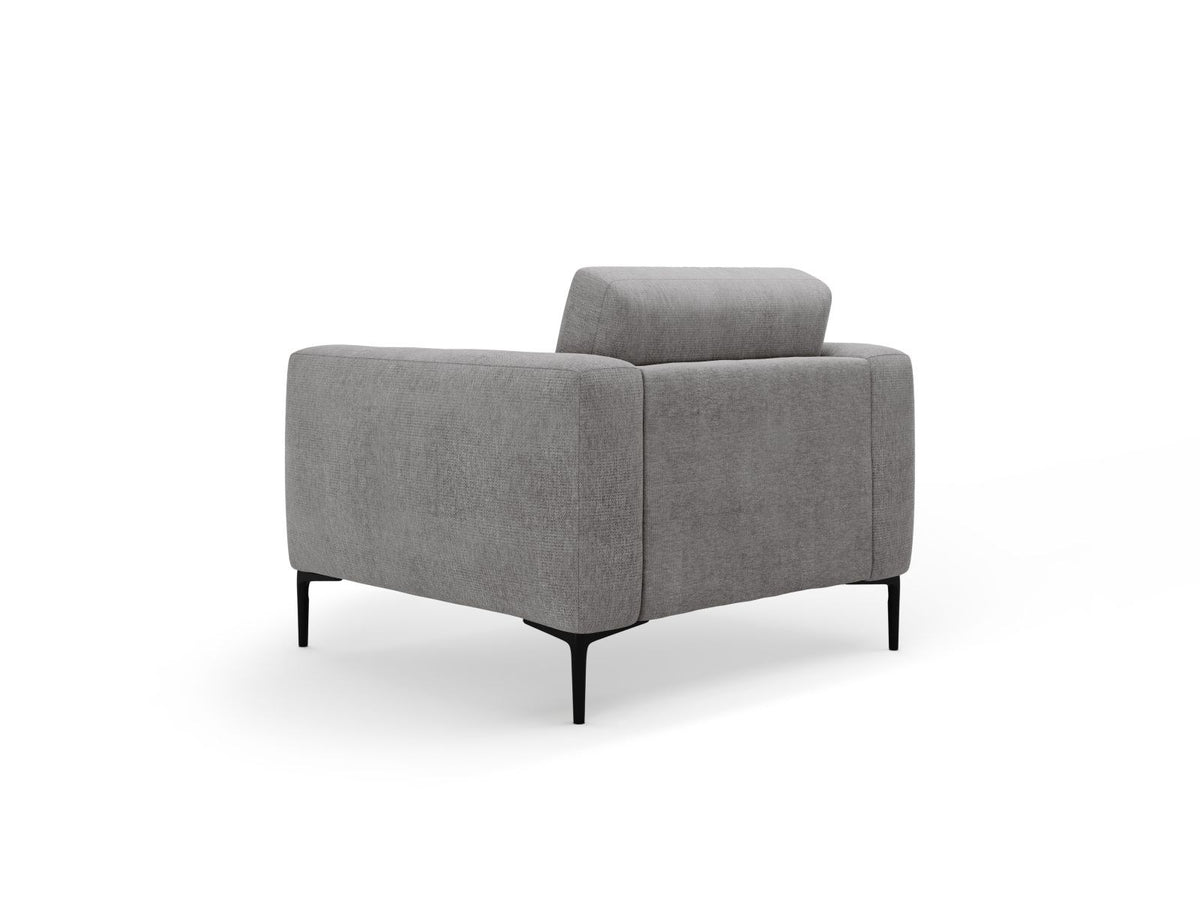 Beige gepolsterter Sessel mit Sorella-Stoffbezug, schwarzen Metallbeinen und Massivholzrahmen, Frontalansicht auf weissem Hintergrund.