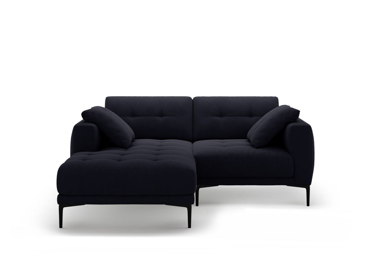 Beige-farbenes Samtsofa Lazio als 2-Sitzer Ecksofa links mit Récamiere, Massivholzrahmen und schwarzen Metallbeinen, Frontalansicht.