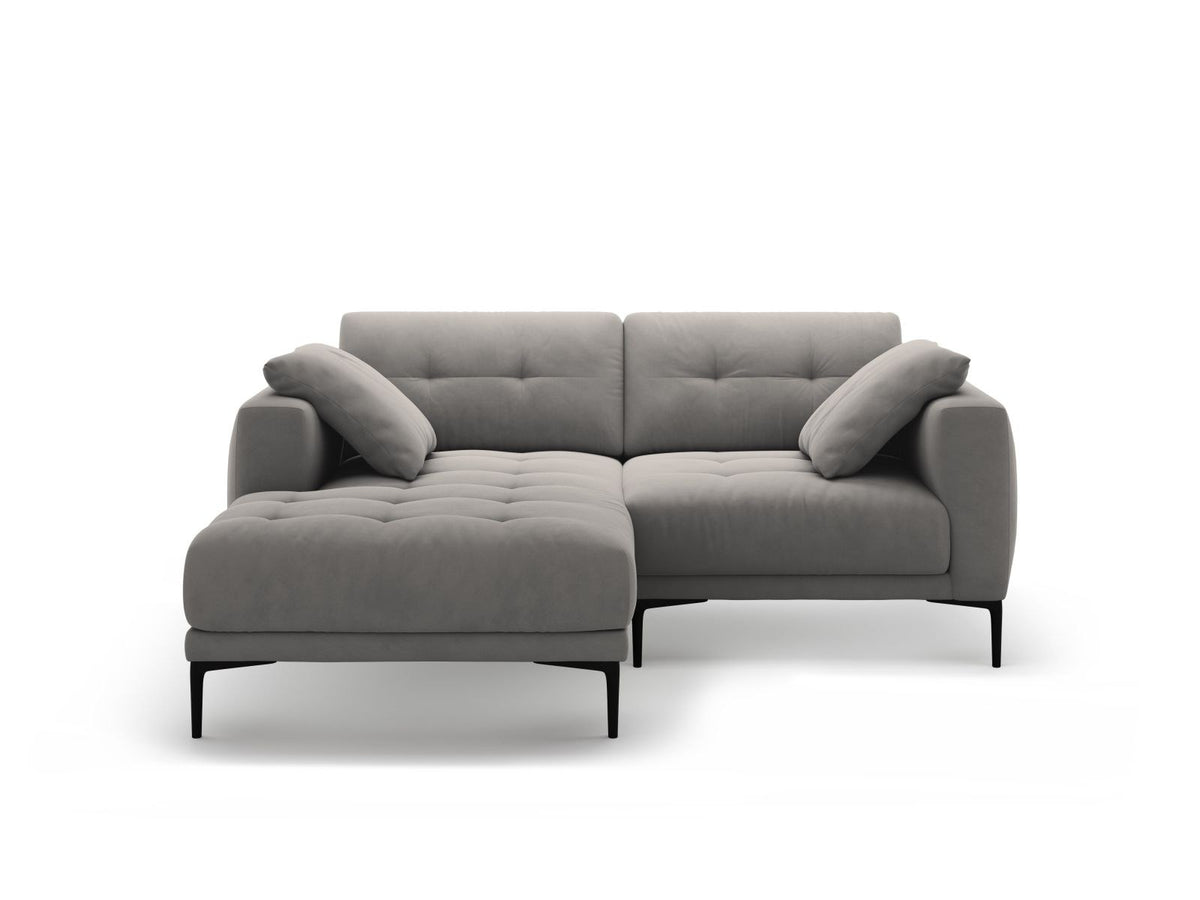 Beige-farbenes Samtsofa Lazio als 2-Sitzer Ecksofa links mit Récamiere, Massivholzrahmen und schwarzen Metallbeinen, Frontalansicht.