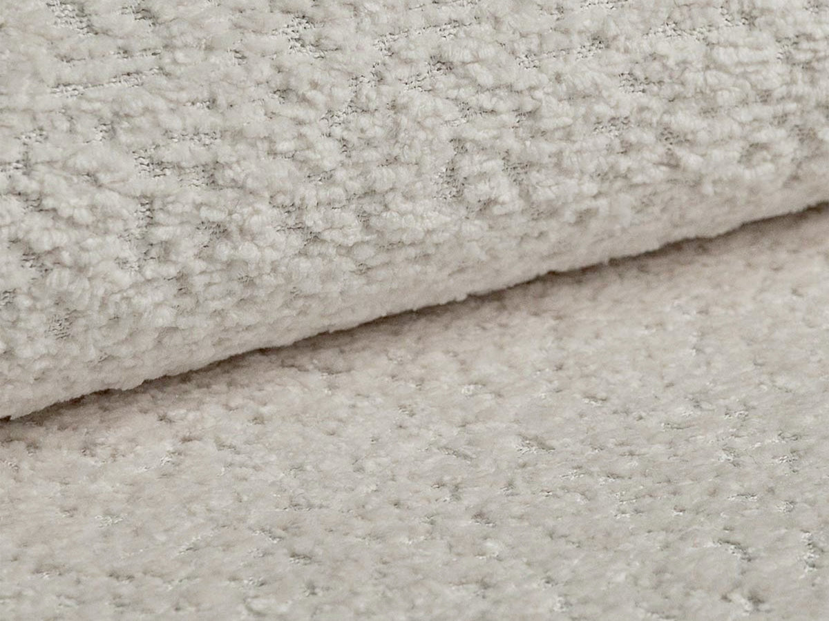 Quadratisches Kissen Kemi 18cm mit Bouclé-Stoff in Coral, Farbe Light Beige, dekorativ auf einem Sofa platziert.