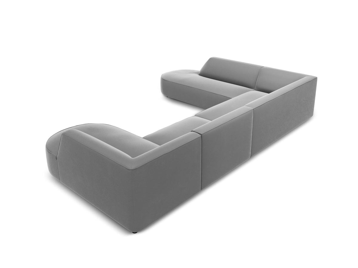 Panorama-Ecksofa links mit Samtbezug in Beige, massivem Holzrahmen und schwarzen Kunststoffbeinen, Modell Siena von Cosmopolitan Design.