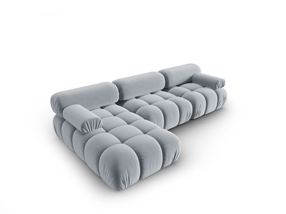 Modulares Ecksofa mit rosa Samtstoff, schwarzen Kunststoffbeinen und gepolsterter Récamiere, Ansicht von vorne links.