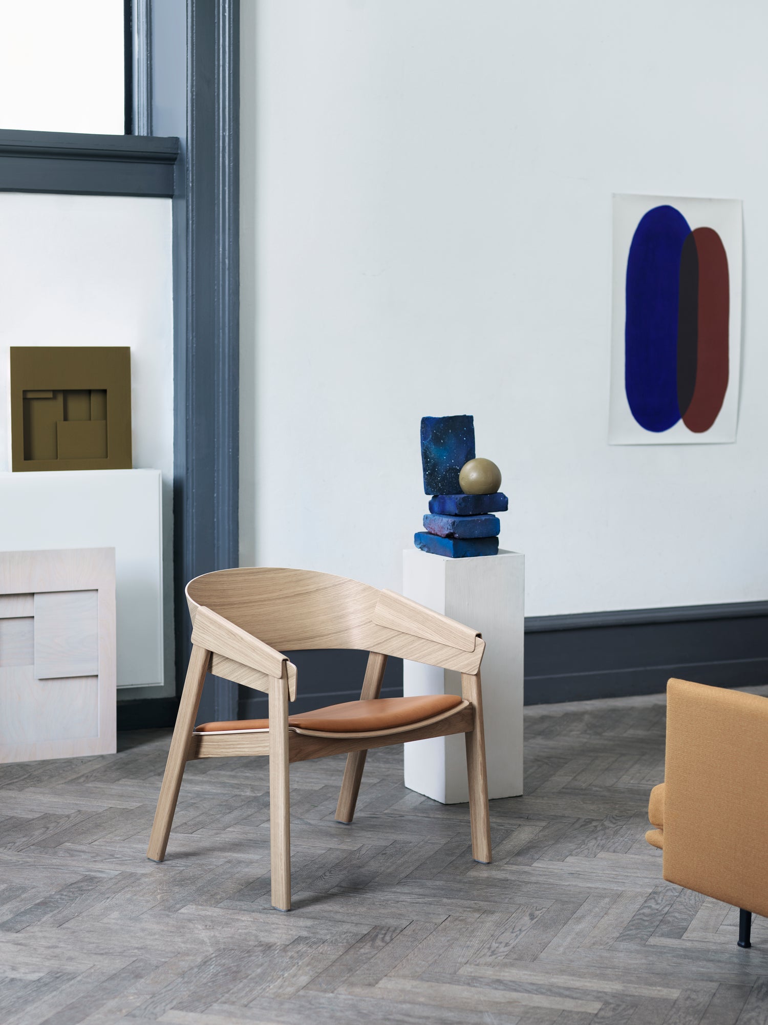 Ein moderner Loungesessel aus Holz mit geschwungenen Armlehnen und klaren Linien, perfekt für ein stilvolles und gemütliches Ambiente.