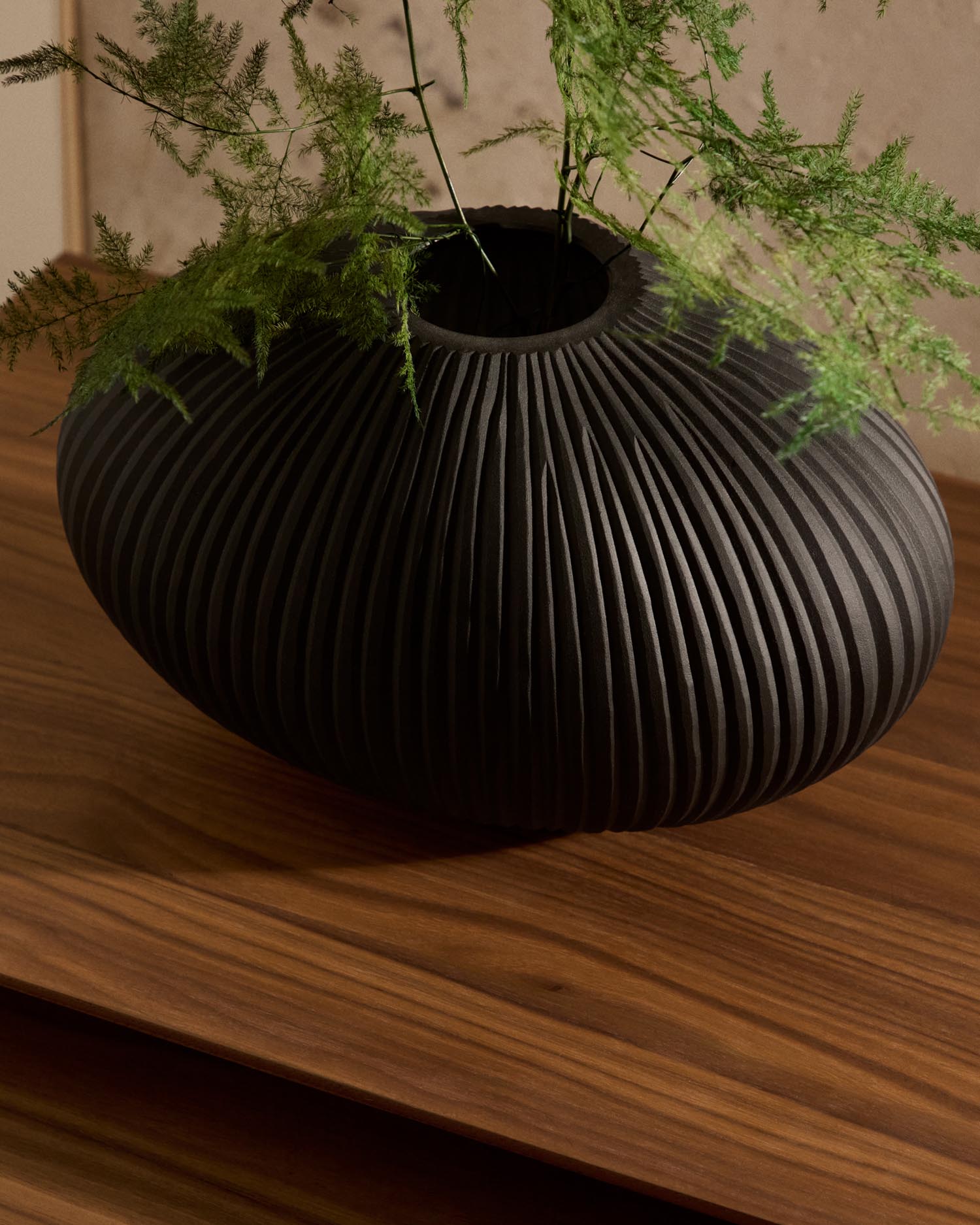 Verleihen Sie Ihrem Raum mit der 19 cm hohen Vase Nivra aus dunkelgrauem Glas von Kave Home einen Hauch von Eleganz und Ruhe.