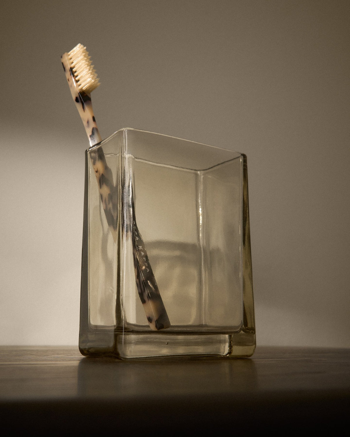 Zahnbürstenhalter aus hellbraunem, durchscheinendem Glas mit geradliniger Form, für die Badablage geeignet.
