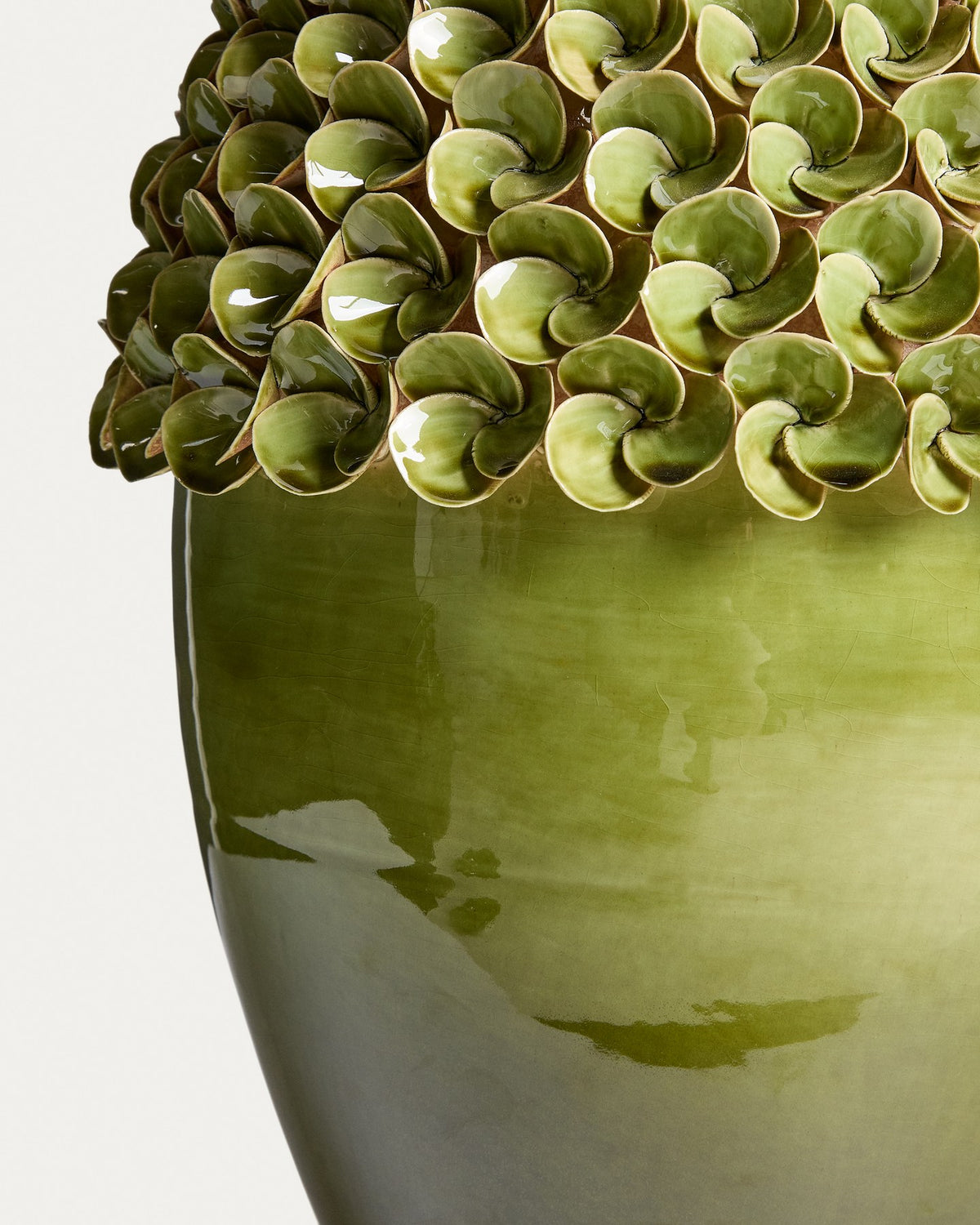 Hellgrüne Keramikvase Ederia von Kave Home mit floralen, handgeformten Blütenelementen, glasierter Oberfläche und rundlicher Form.