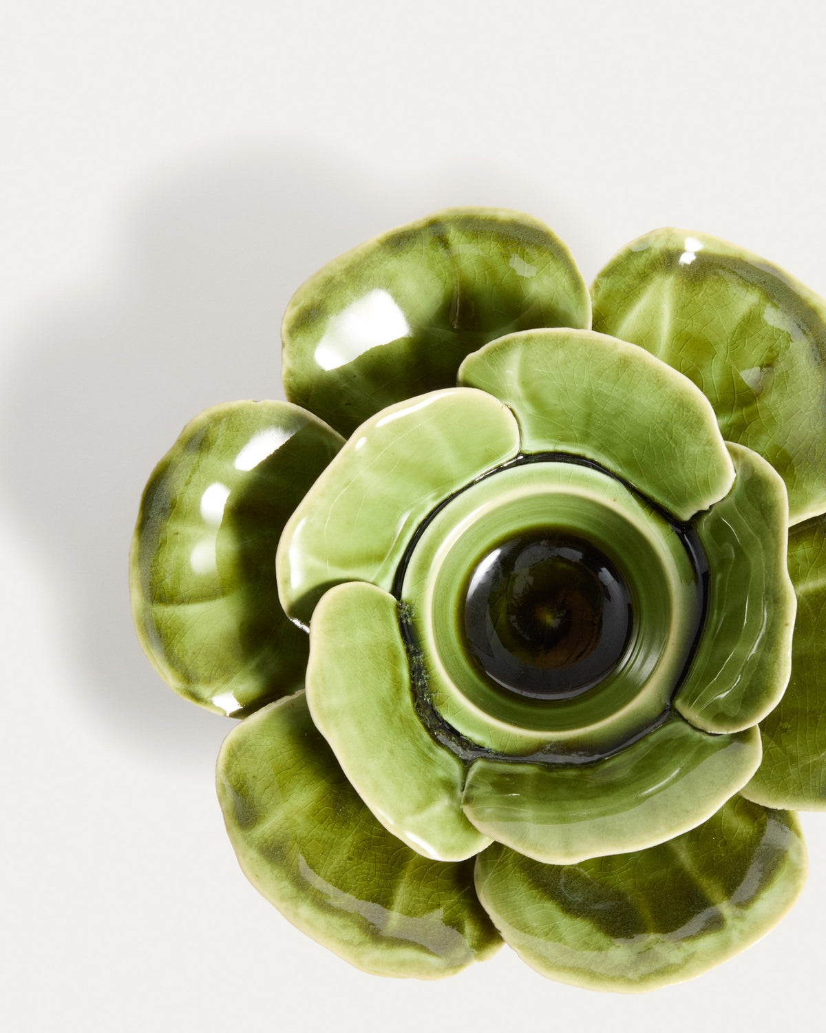 Kerzenständer aus glasierter Keramik in Hellgrün mit floralen, handgeformten Blütenelementen, Durchmesser 20 cm, Höhe 6 cm.