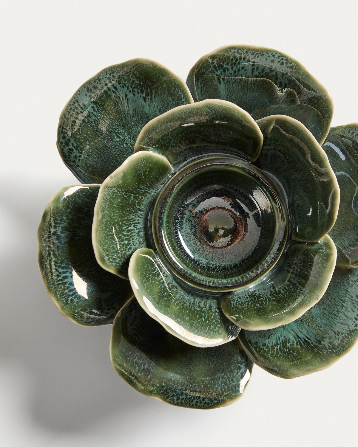 Olivgrüner Kerzenständer aus glasierter Keramik mit floralen, handgeformten Verzierungen, rund, Durchmesser etwa 18 bis 20 cm.
