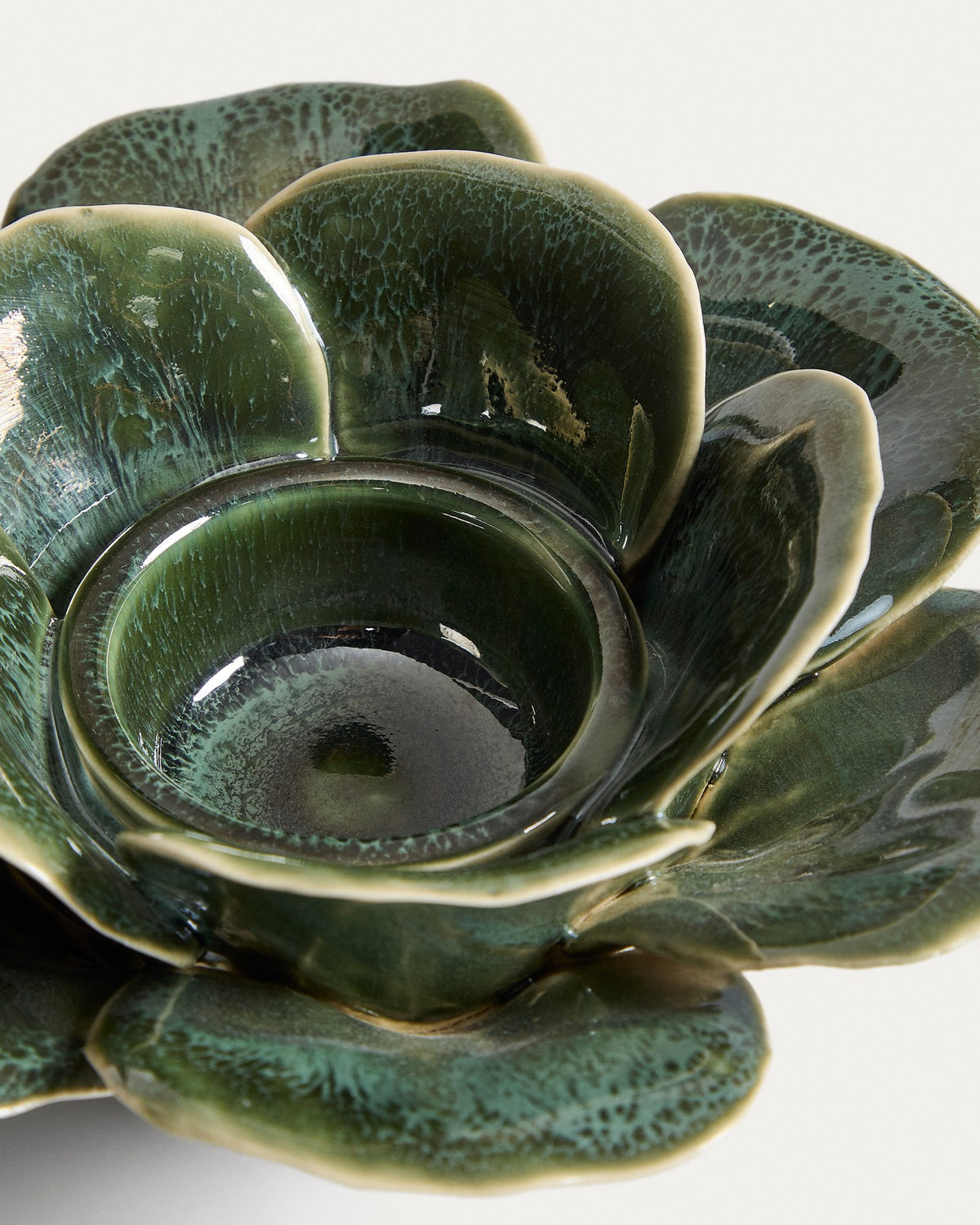 Olivgrüner Kerzenständer aus glasierter Keramik mit floralen, handgeformten Verzierungen, rund, Durchmesser etwa 18 bis 20 cm.