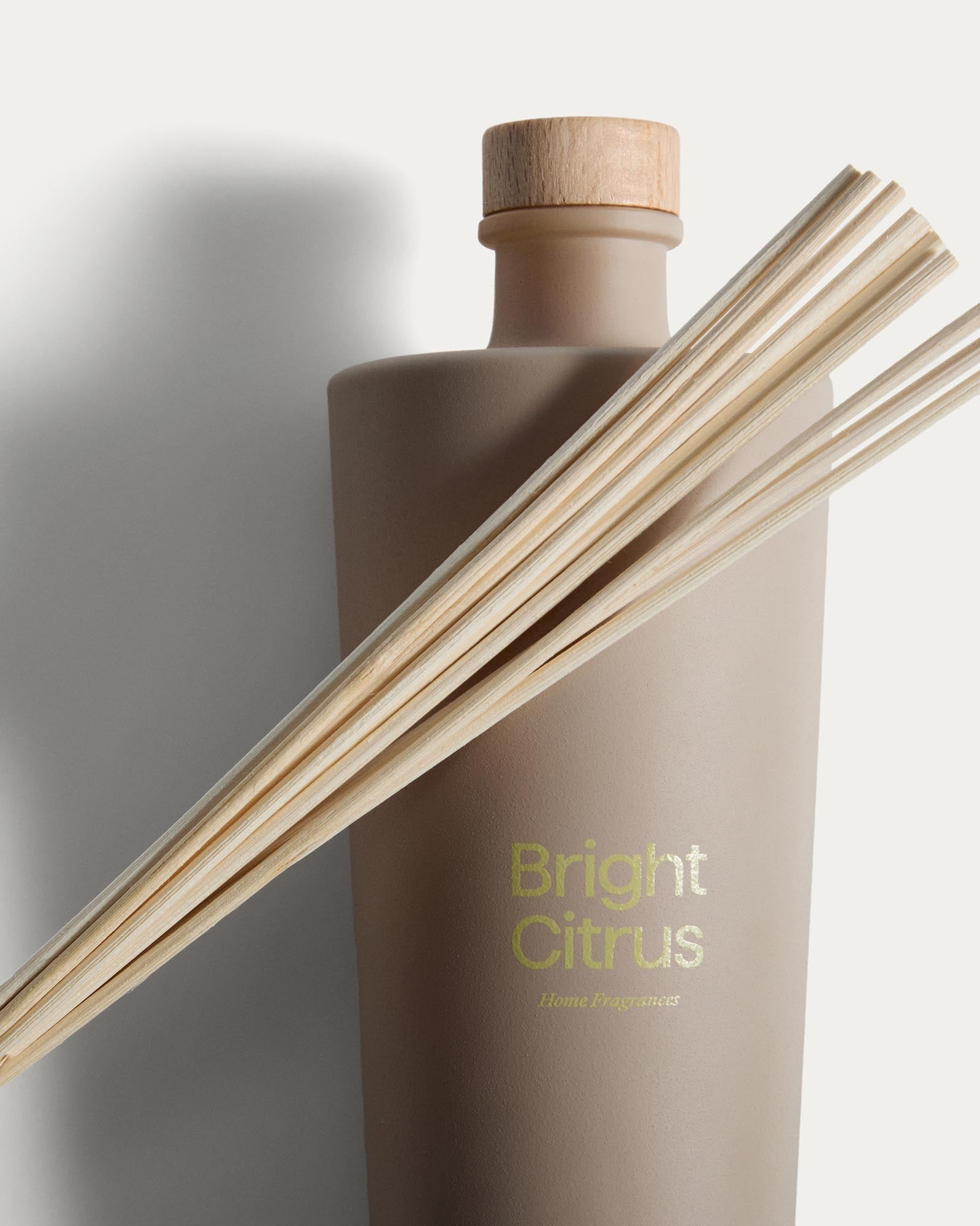 Frischer Citronella-Lufterfrischer Bright Citrus von Kave Home, 500 ml, in einer ansprechenden beige Flasche mit dekorativen Duftstäbchen.