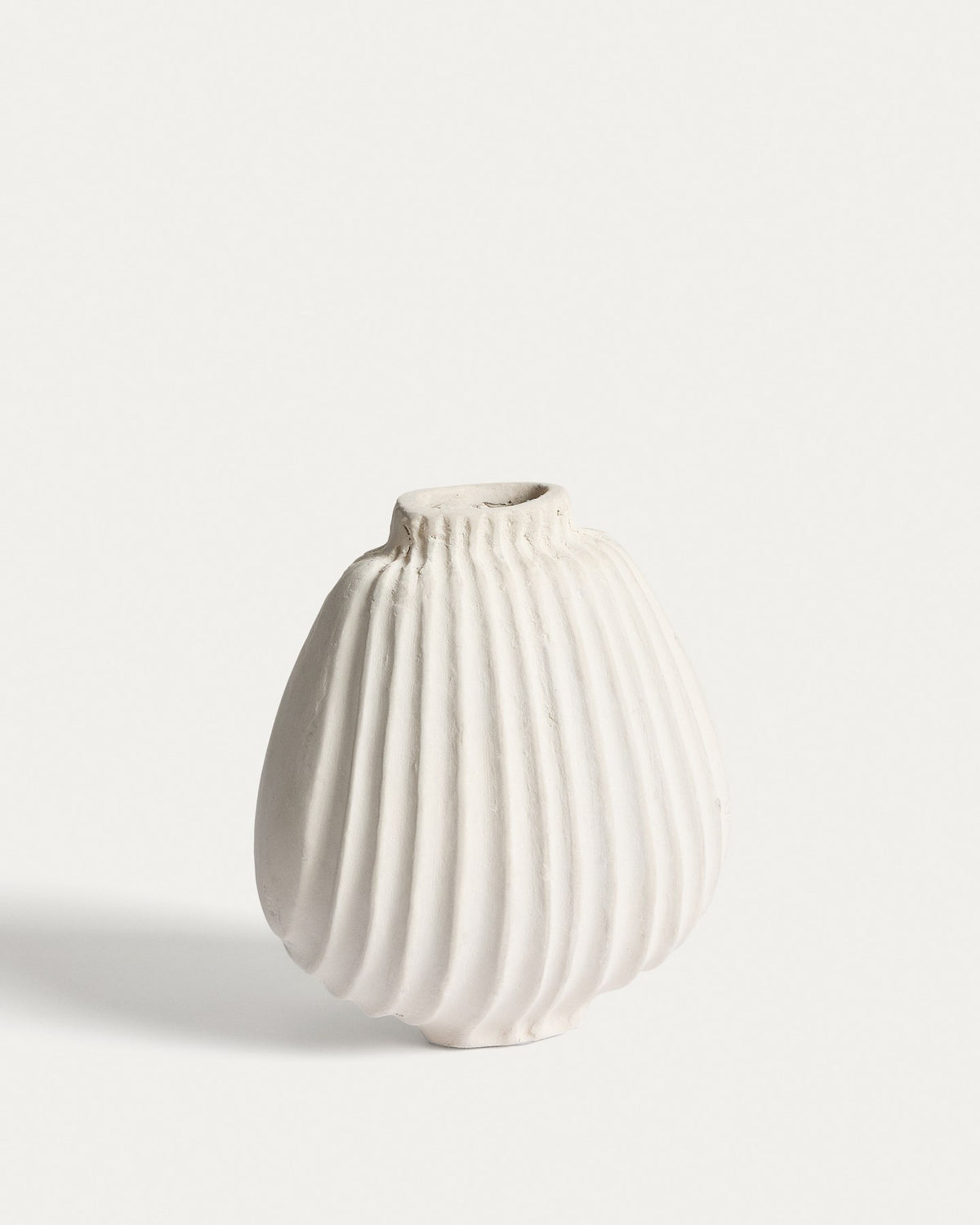 Handgefertigte Vase aus Pappmaché in der Farbe Ecru mit abgerundeter Form und feinen Relief-Linien auf der gesamten Oberfläche.