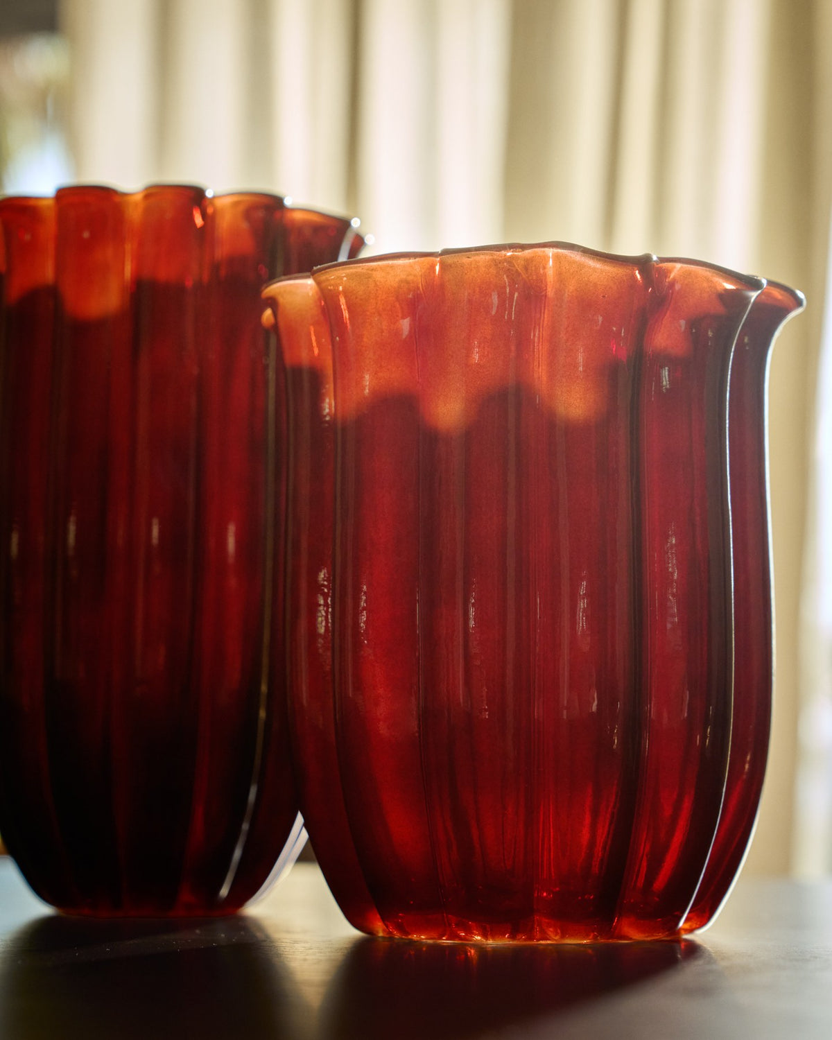 Burgunderrote Glas-Vase mit vertikalem Relief und rundem Öffnungsdurchmesser von 14,5 cm, Höhe 25 cm, aus durchgefärbtem Glas.