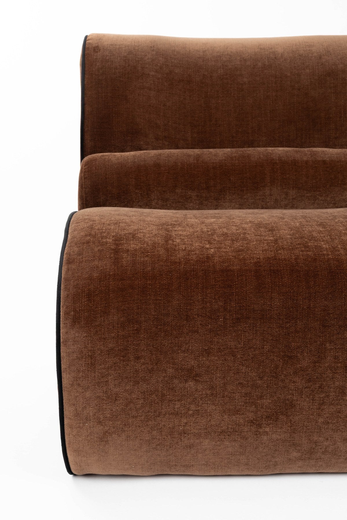 Dunkelbrauner Lounge Chair Donna von Dutchbone mit gepolsterter Sitzfläche, runden Formen und dunkler Paspel entlang der Rundungen.