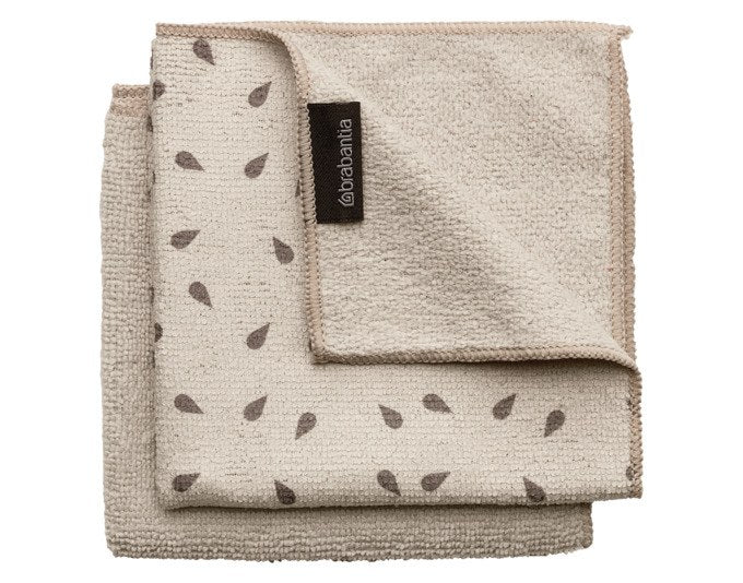 Zwei quadratische Microfasertücher in soft beige und weiss, gefaltet übereinander liegend, mit feiner Gewebestruktur sichtbar.
