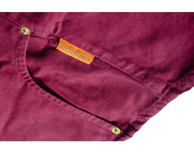 Kochschürze in Aubergine und Braun aus Canvas mit Rundhalsausschnitt, schmalen Seitenteilen, fünf Taschen und Knöpfen zur Anpassung.