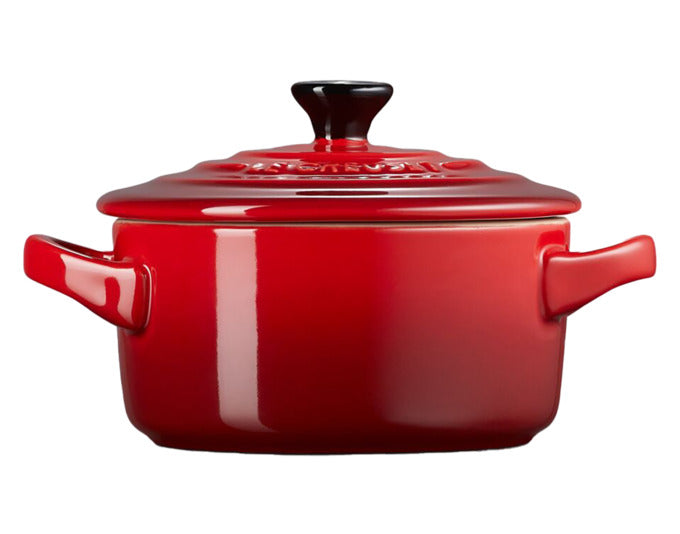 Kleine, kirschrote Mini-Cocotte von LE CREUSET mit einem Durchmesser von 10 cm und einer Höhe von 5 cm, ideal für individuelle Portionen.