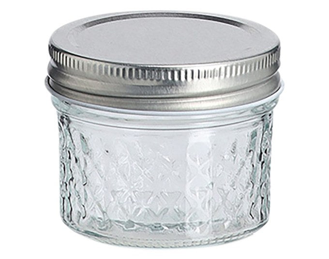 Transparentes Vorratsglas mit strukturierter Glasoberfläche und grauem Metalldeckel, rund, Durchmesser 7 cm, Höhe 6 cm.