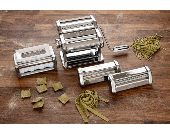 Silberne MARCATO Nudelmaschine Atlas Plus aus Chromstahl mit drei Zubehörteilen für Linguine, Pappardelle und Ravioli auf weissem Hintergrund