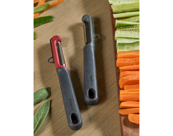 Zwei ZYLISS Schäler in Grau und Rot: Universal- und Tomatenschäler mit ergonomischem Griff aus Weizenstrohmaterial.