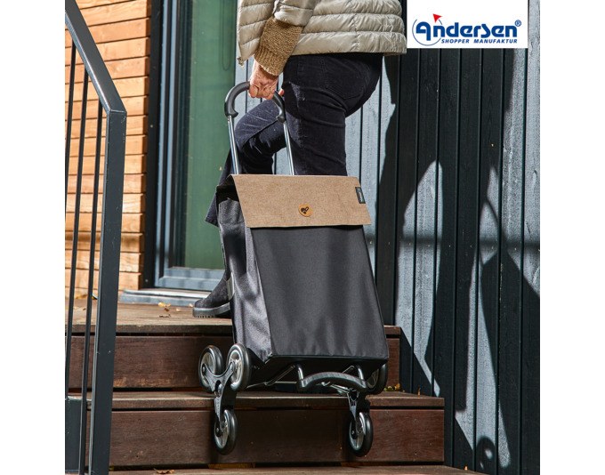 Sandfarbener Einkaufswagen mit leichtem Aluminiumgestell, abnehmbarer Tasche in Sand und zwei Treppensteigerrädern mit je drei kleinen Laufrollen.
