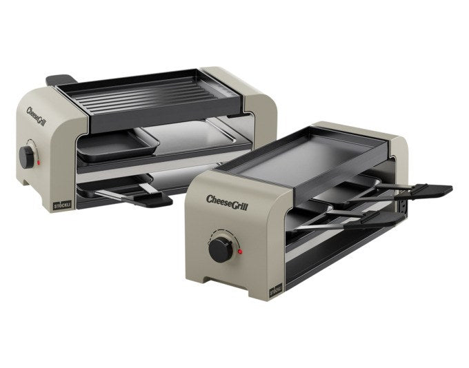 Tischgrill STÖCKLI CheeseGrill 2 Connect Set in Ivory Gold mit vier Pfännchen, Wende-Grillplatte und Parkdeck auf hellem Hintergrund.