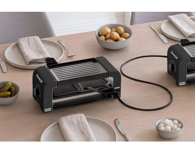 Schwarzer STÖCKLI Tischgrill CheeseGrill 2 Connect mit zwei antihaftbeschichteten Pfännchen und wendbarer Grillplatte, Ansicht von vorne.