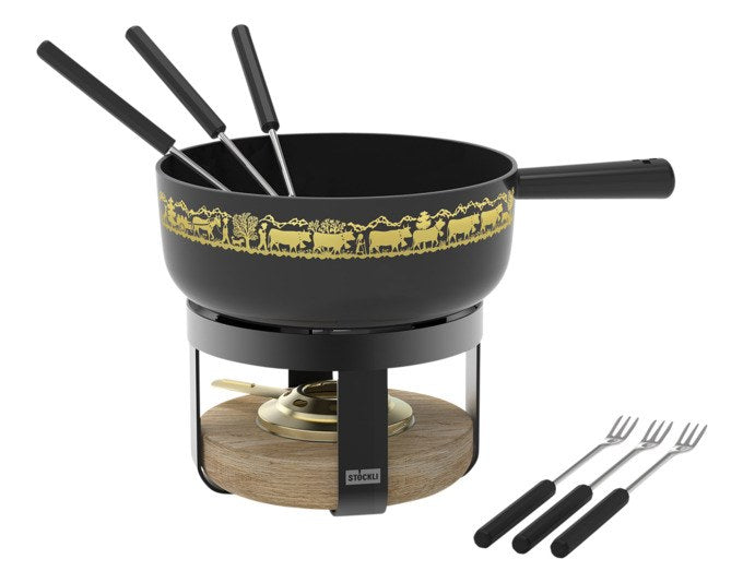 Schwarzes Fondue-Set STÖCKLI Pilatus Wood Classic mit Gusseisen-Caquelon, goldenem Alp-Dekor, Holzeinsatz-Rechaud und sechs Fonduegabeln.