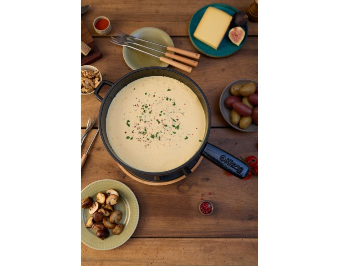 Schwarzes Fonduecaquelon aus emailliertem Gusseisen, rund, ø 23 cm, mit Griffen, auf neutralem Hintergrund fotografiert.