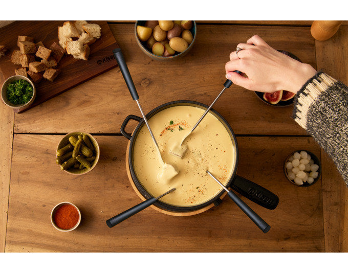 Schwarzes Fondue Set KISAG Alpsommer mit rundem Caquelon aus Gusseisen, Rechaud in Chrom/Silber und sechs Fonduegabeln auf weissem Hintergrund.