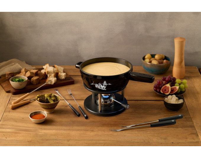Schwarzes Fondue Set KISAG Alpsommer mit rundem Caquelon aus Gusseisen, Rechaud in Chrom/Silber und sechs Fonduegabeln auf weissem Hintergrund.