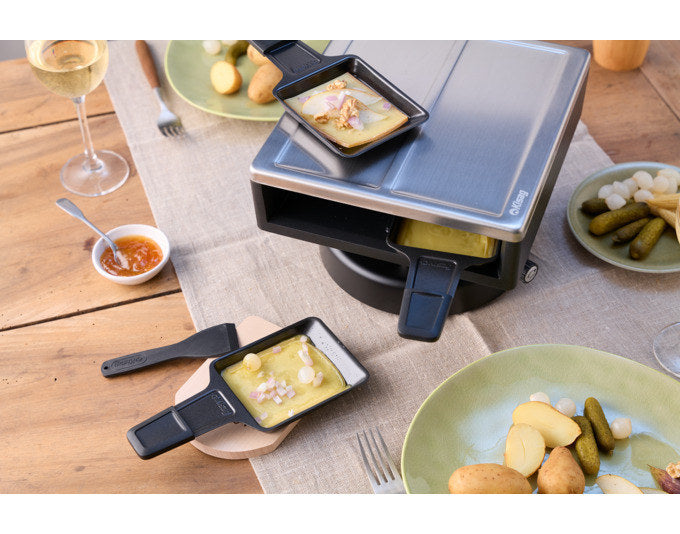Raclette-Aufsatz SIERRE von KISAG aus Aluminium-Druckguss mit Edelstahldeckel, inklusive vier Pfännchen und Spachteln, Farben Schwarz und Silber.