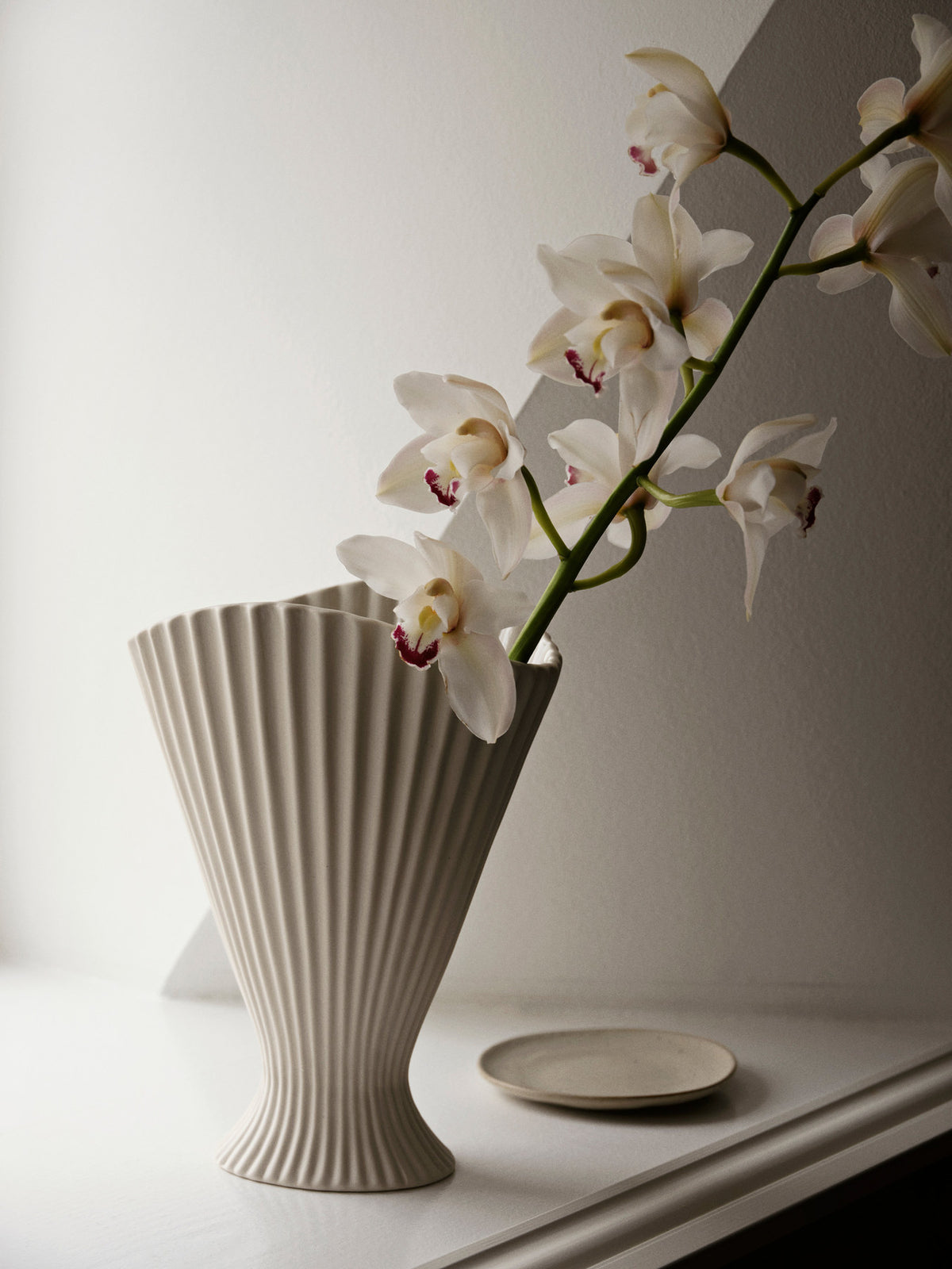 Fountain Vase von Ferm Living aus Steingut in Off-White, aussen matt und unglasiert, innen glasiert, mit gefältelter, geschwungener Form.