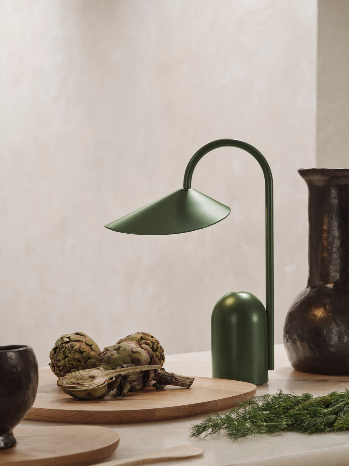 Drei Schneidebretter der Serie Cairn von Ferm Living aus dunkelbraunem, karbonisiertem Eschenholz mit organischen, abgerundeten Formen auf hellem Hintergrund.