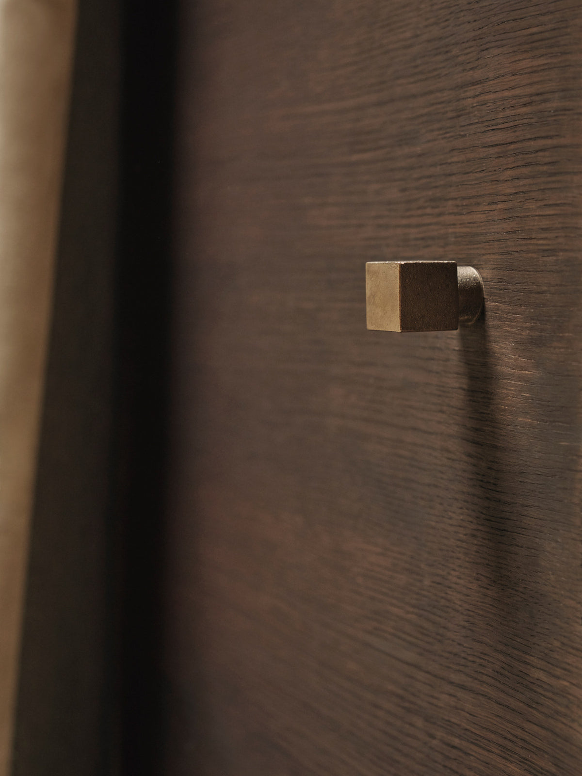 Kleiderhaken Square von Ferm Living aus massiv gegossenem Messing, geometrische Form aus Würfel und Zylinder, Farbton Casted Brass, Nahaufnahme.