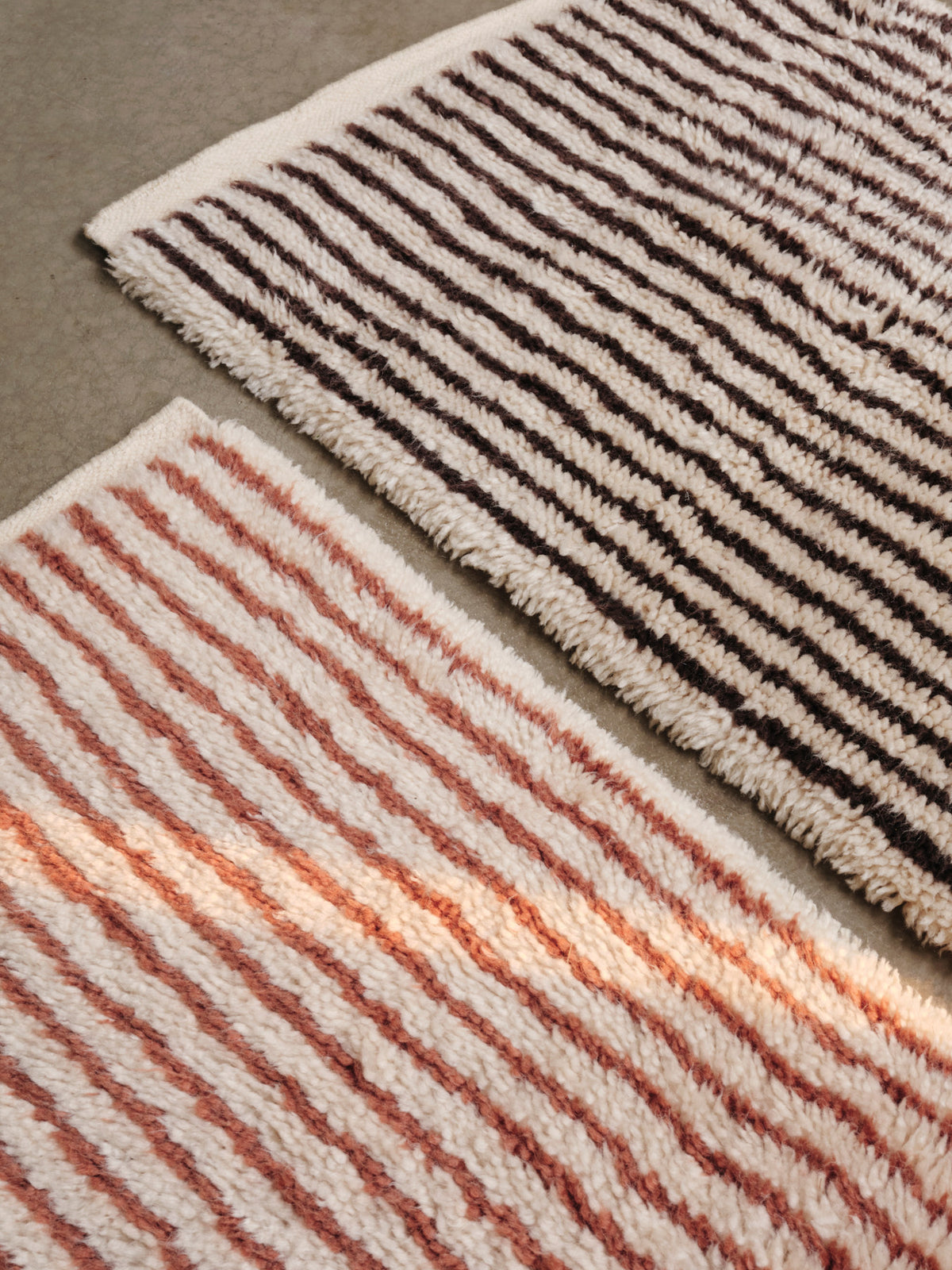 Kami Knüpfteppich von Ferm Living in Offwhite/Red Brown, handgeknüpft aus neuseeländischer Wolle mit Baumwollanteil, schlichtes Streifenmuster und Webkanten.