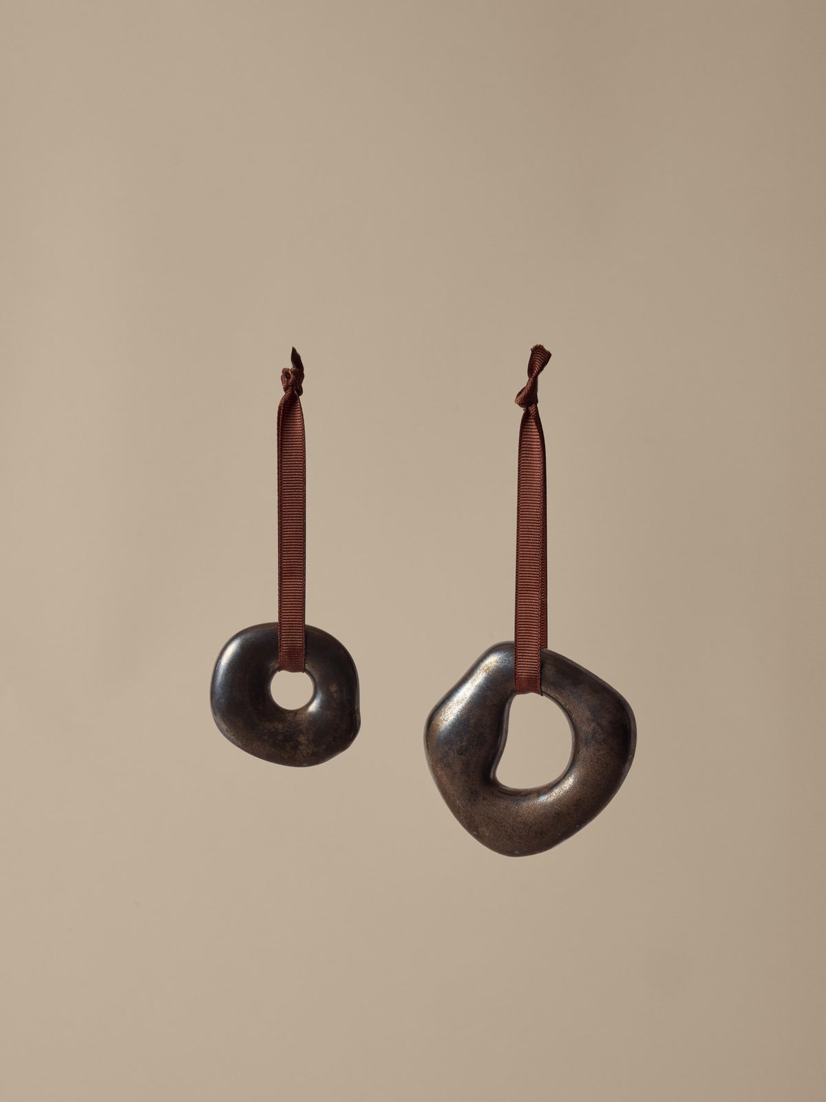 Zwei runde Ornamente aus galvanisiertem Steingut in Messing-Finish mit Polyesterband, abstrakte organische Form, Weihnachtsdekoration.