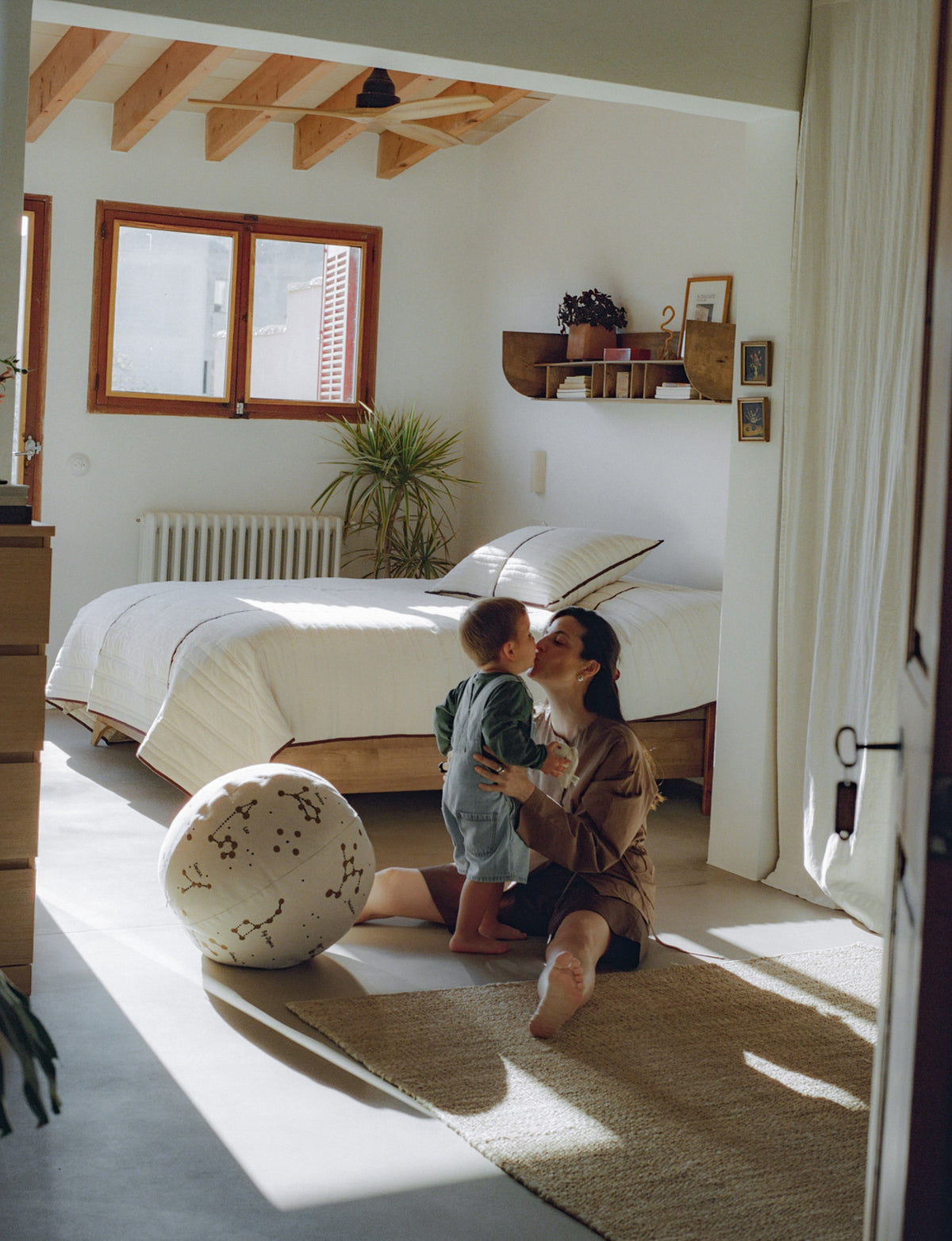 Gesteppte Tagesdecke Vari von Ferm Living aus Bio-Baumwolle in Natural mit Paspelierung in Dark Chocolate, auf Bett drapiert.