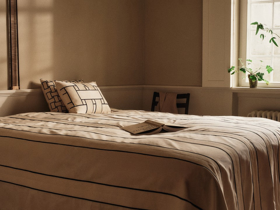 Rechteckiges Lattice Kissen von Ferm Living in elegantem Off-white und Schwarz, ideal für stilvolle Wohnräume.