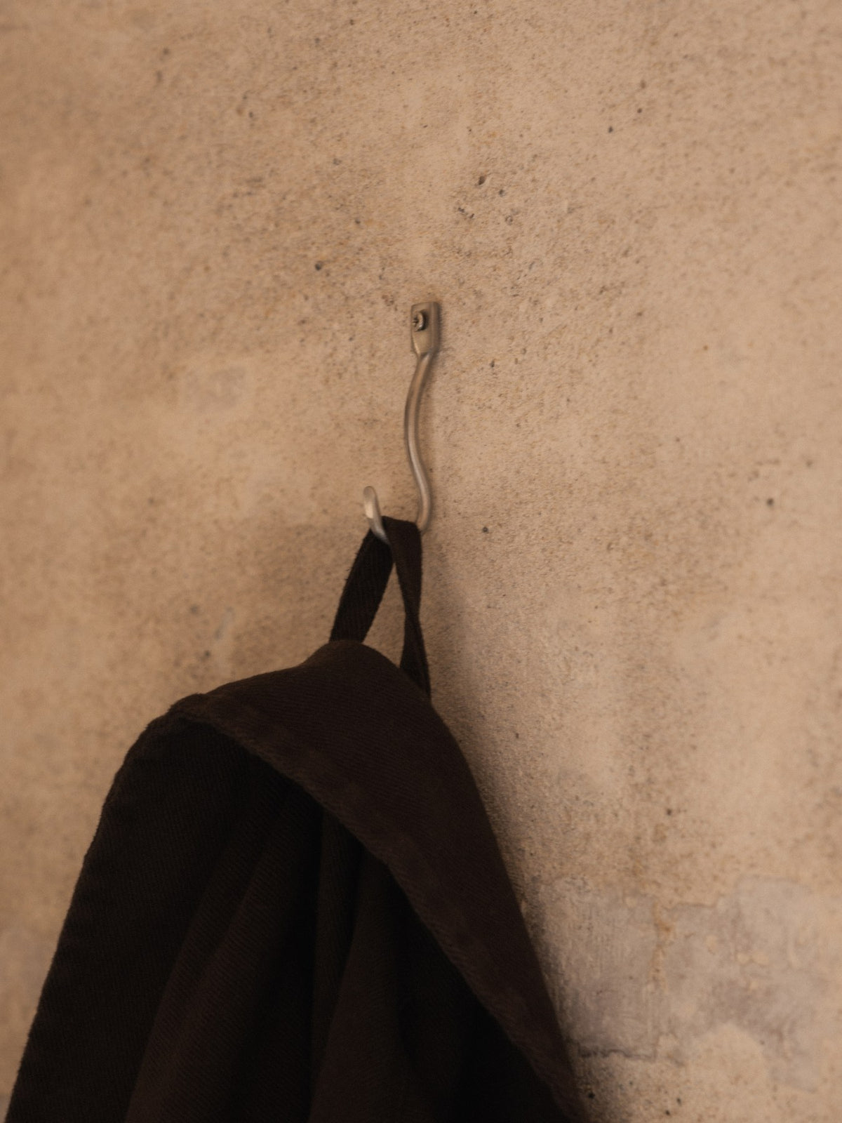 Drei skulptural geformte Wandhaken aus Edelstahl, handgefertigt, mit leicht geschwungener Form für Bad oder Flur.