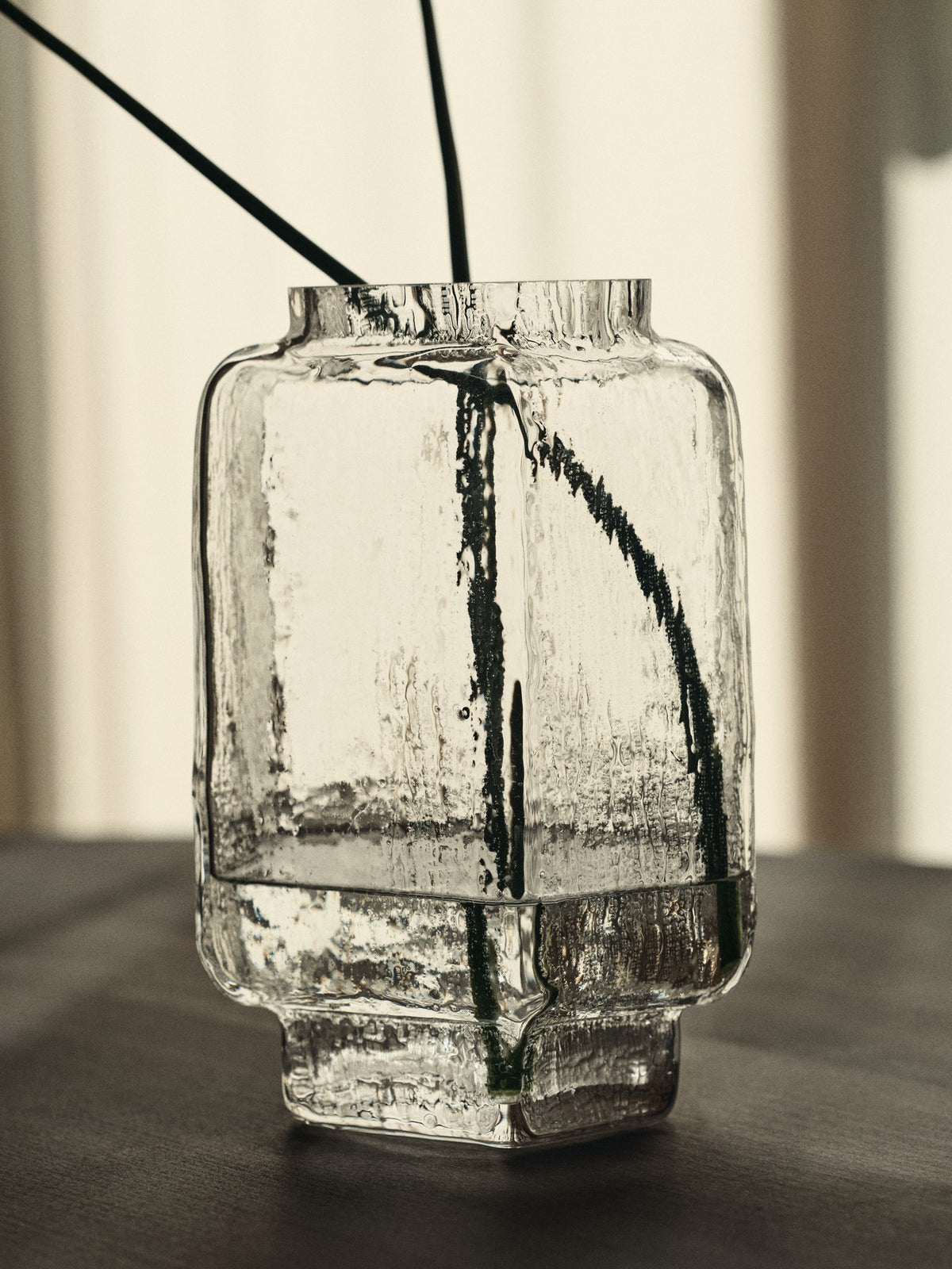 Klare Glasvase Mokuri H25 von Ferm Living mit facettierter Oberfläche und vertikalen Linien, mundgeblasen aus recyceltem Glas.