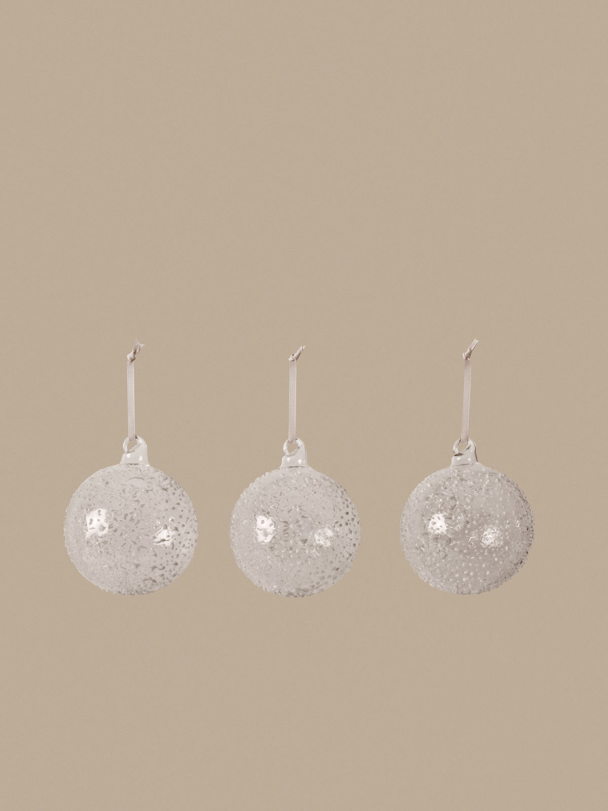 Drei mundgeblasene Glaskugeln in Weiss mit strukturierter Oberfläche und cremefarbenem Polyesterband, Ferm Living Ornament-Set.