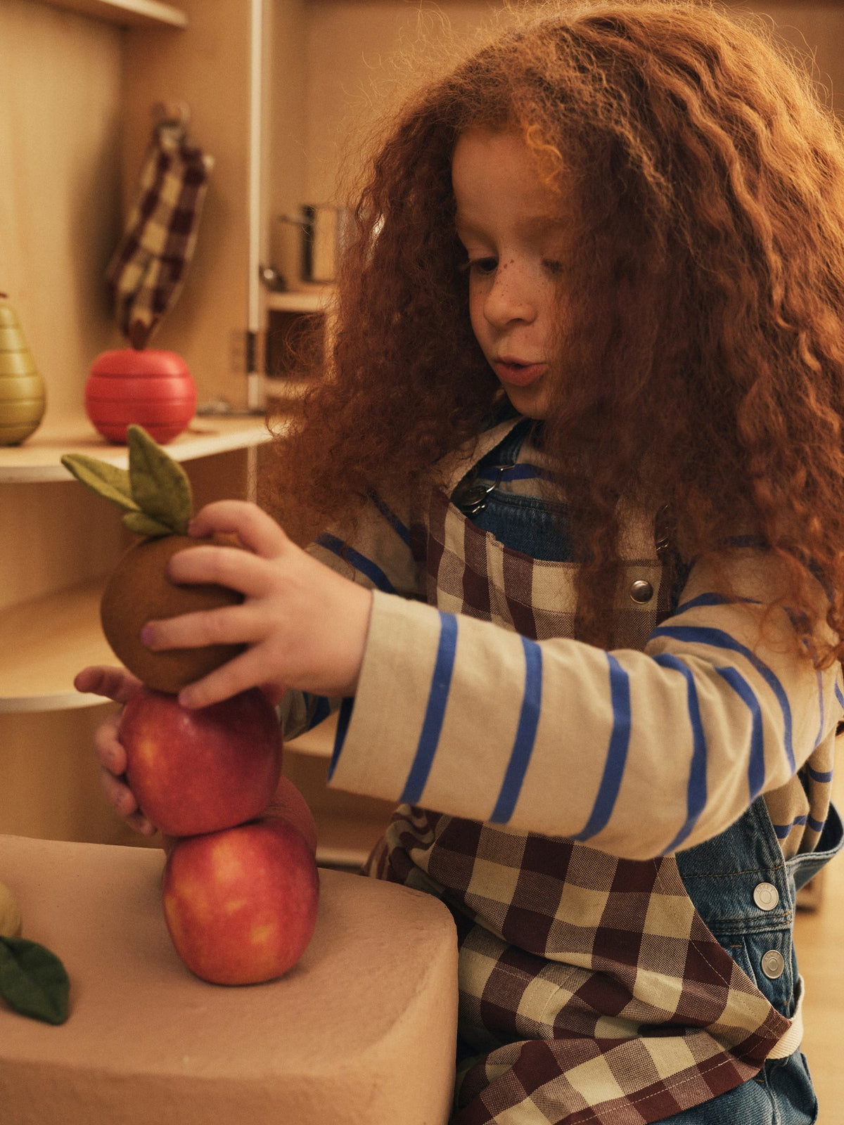 Bothy Kinderküchen-Set von Ferm Living: Schürze, Ofenhandschuh und Geschirrtuch aus Bio-Baumwolle im Karomuster, Farbe Zimt/Graugrün.