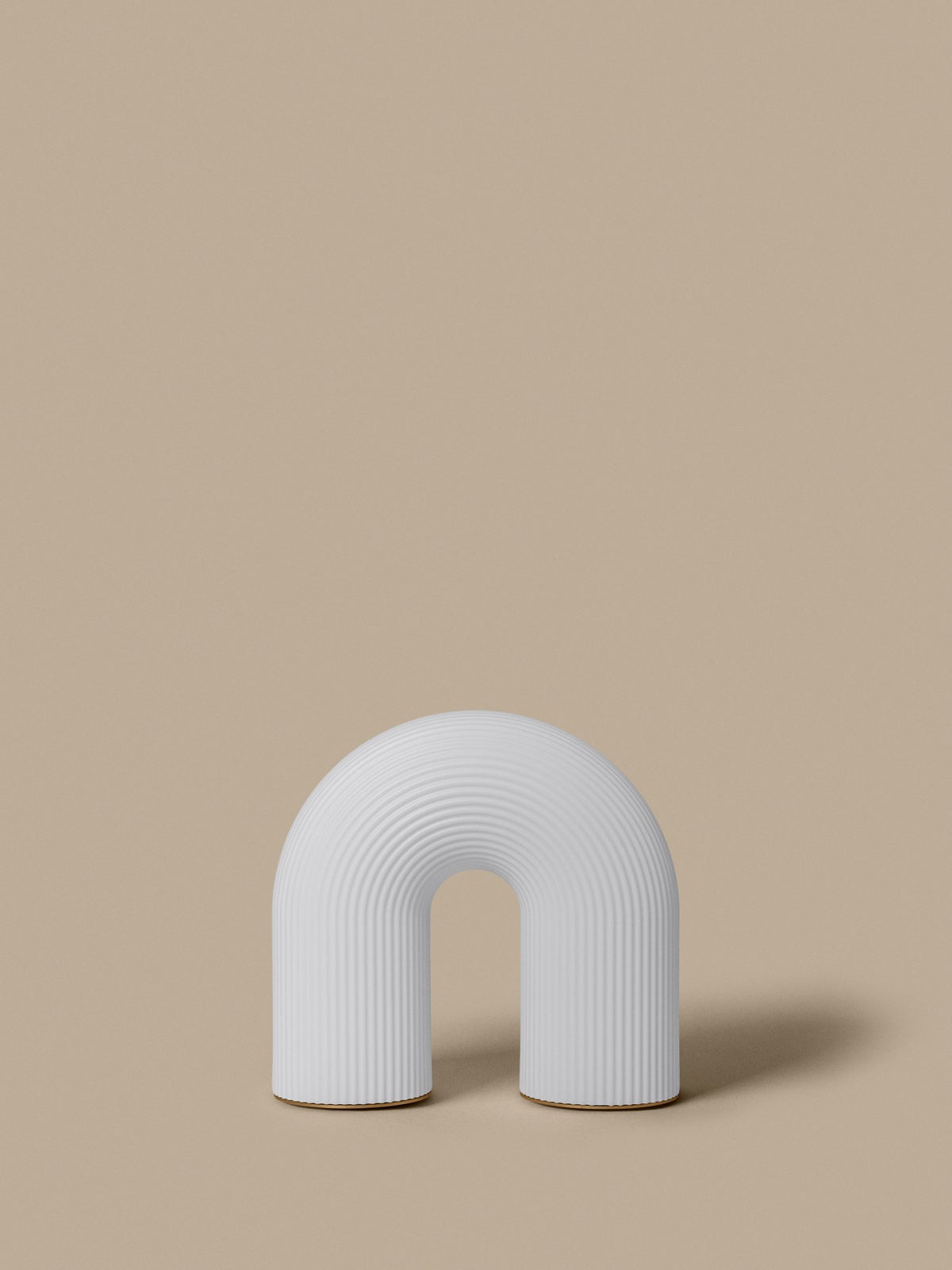 Weisse tragbare Tischleuchte Vuelta H25 von Ferm Living mit bogenförmigem Design aus HDPE-Basis und vernickelten Stahlfüssen, ohne sichtbares Kabel.
