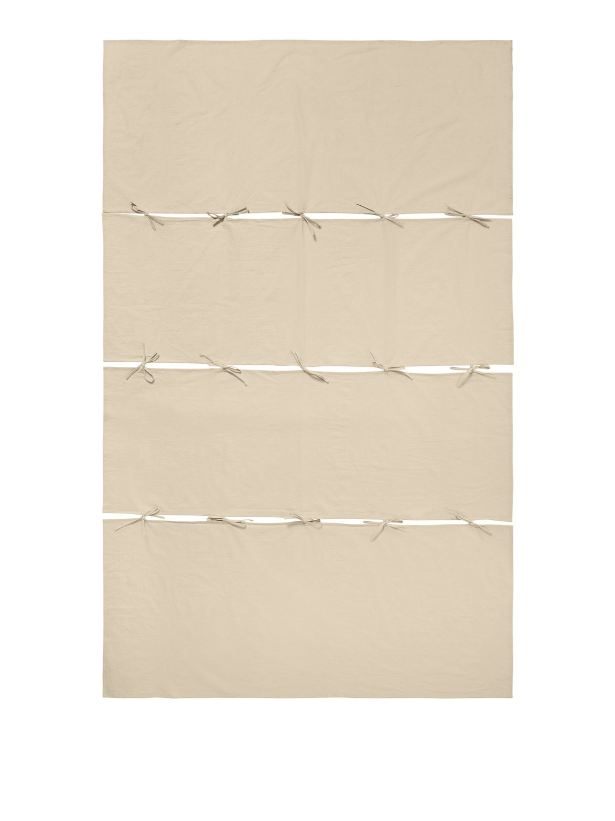 Modulare Tischdecke Link von Ferm Living aus Bio-Baumwolle in Pergament, bestehend aus zwei End- und zwei Mittelteilen mit Bändern verbunden.