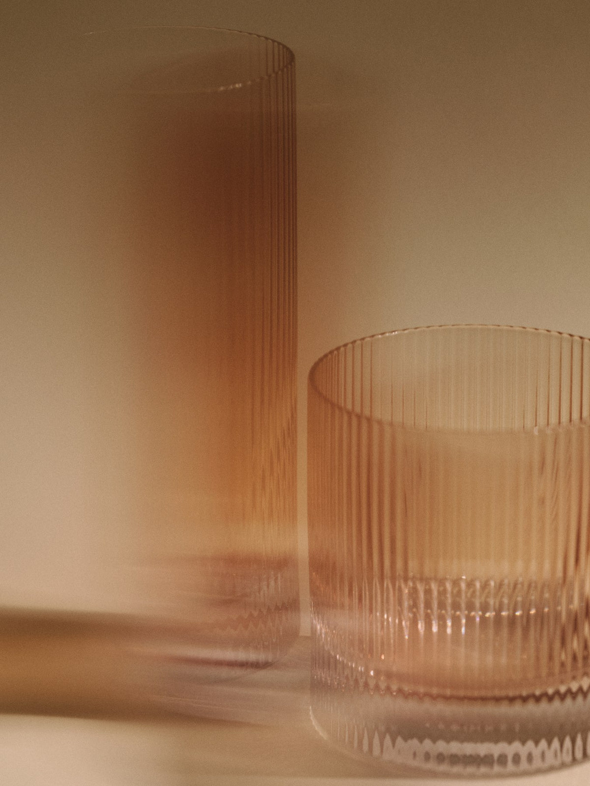 Zwei Highball-Gläser aus mundgeblasenem, recyceltem Glas mit geriffelter Oberfläche in Blush, Höhe 16 cm, Durchmesser 7 cm.