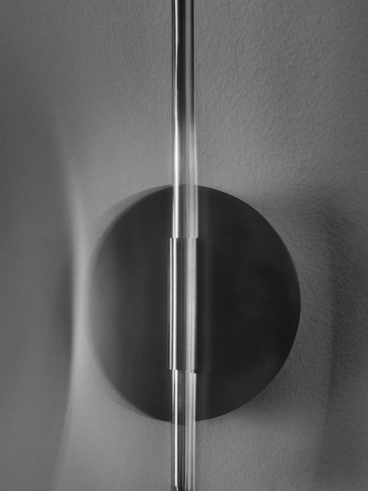 Arum Swivel Wandleuchte von Ferm Living in Edelstahl mit organisch geformtem Lampenschirm, Innenseite matt Off-White, an der Wand montiert.