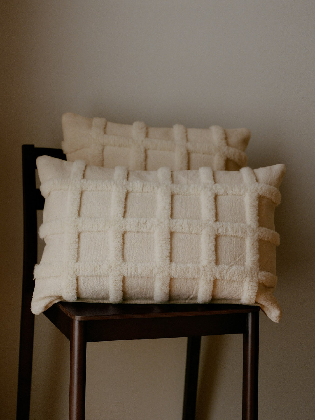 Rechteckiges Deko Kissen Norte Grid von Ferm Living in Off-White, handgetuftet aus Wolle und Baumwolle mit geometrischem Gittermuster.