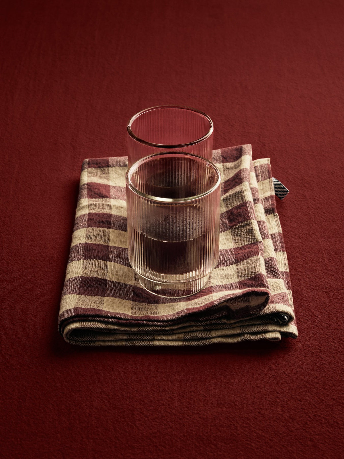 Zwei klare, doppelwandige Ripple Thermogläser von Ferm Living mit geriffelter Oberfläche aus mundgeblasenem Glas, nebeneinander auf hellem Untergrund.