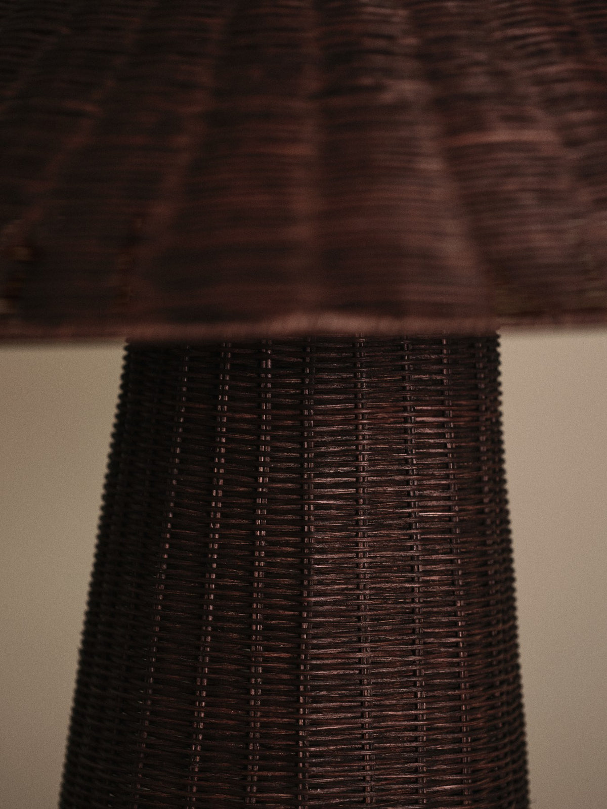 Dou Tischleuchte von Ferm Living in Dunkelbraun, Lampenschirm aus handgeflochtenem Rattan auf rundem Sockel mit Eisenstruktur.