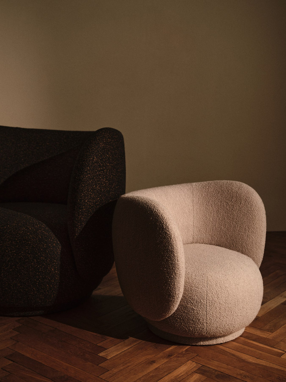 Loungesessel Rico von Ferm Living mit geschwungener Form, Vanir-Stoff in Schwarz/Honig, gepolsterter Sitzfläche und Rückenlehne aus Formschaum.